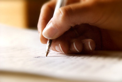 Photo of a hand with a pen in the act of writing